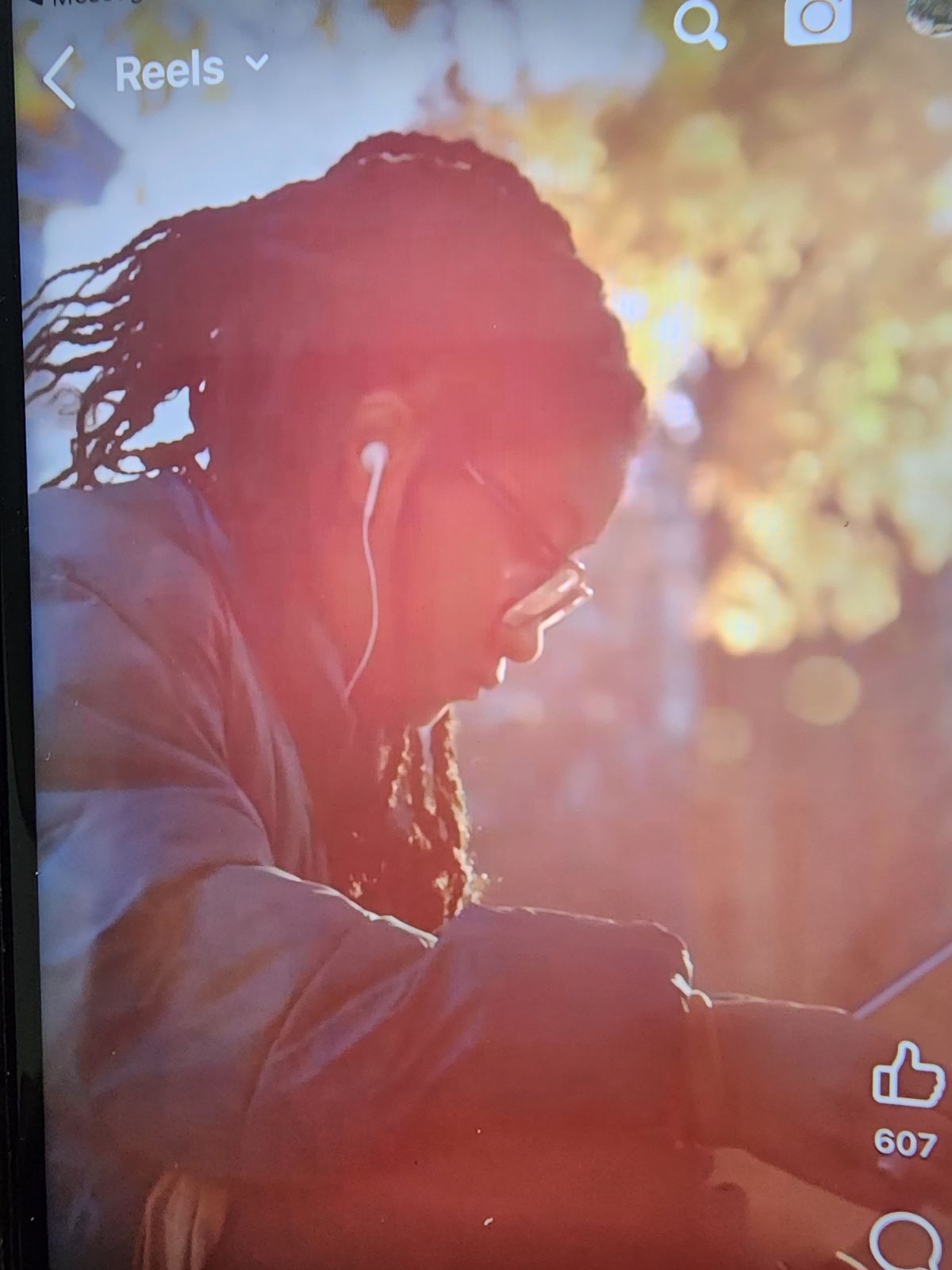 Avery is wearing a green jacket and sitting outside on Princeton's campus reading on her computer and listening to music.