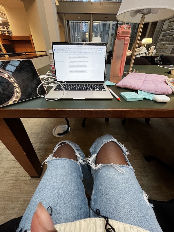 A laptop, iPad, and water bottle on a library table