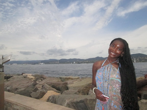 A girl in a blue dress in front of the Mediterranean Sea.