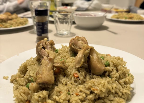 A plate of chicken and green rice.