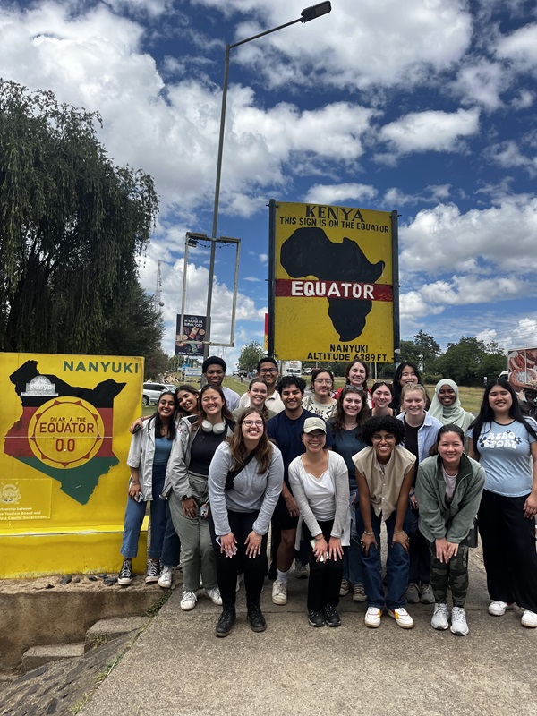 Group photo at a sign marking the equator in Kenya